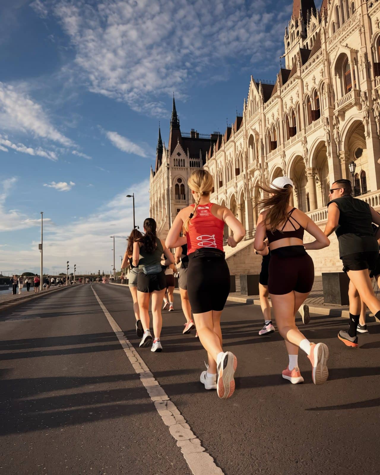 Runners passing the Hungarian Parliament at golden hour